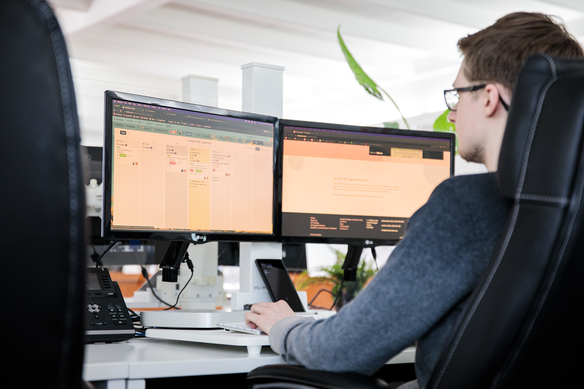 A website designer sat at his desk, looking at a computer
